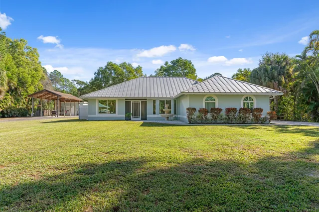 a front view of a house with swimming pool having outdoor seating