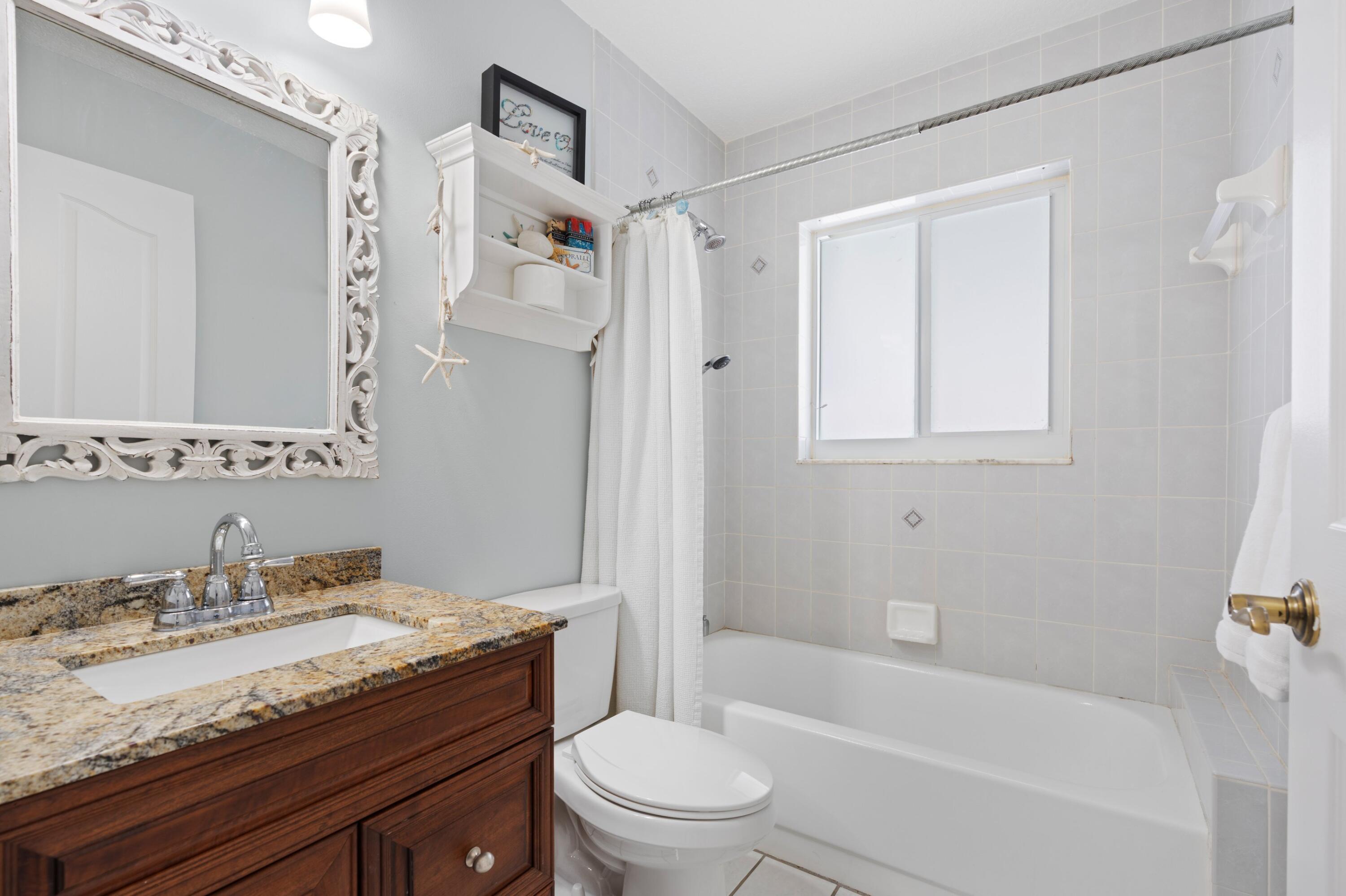 17392 Mellen Lane Jupiter, FL 33478 - Photo 12 of 38 a bathroom with a granite countertop sink toilet and shower
