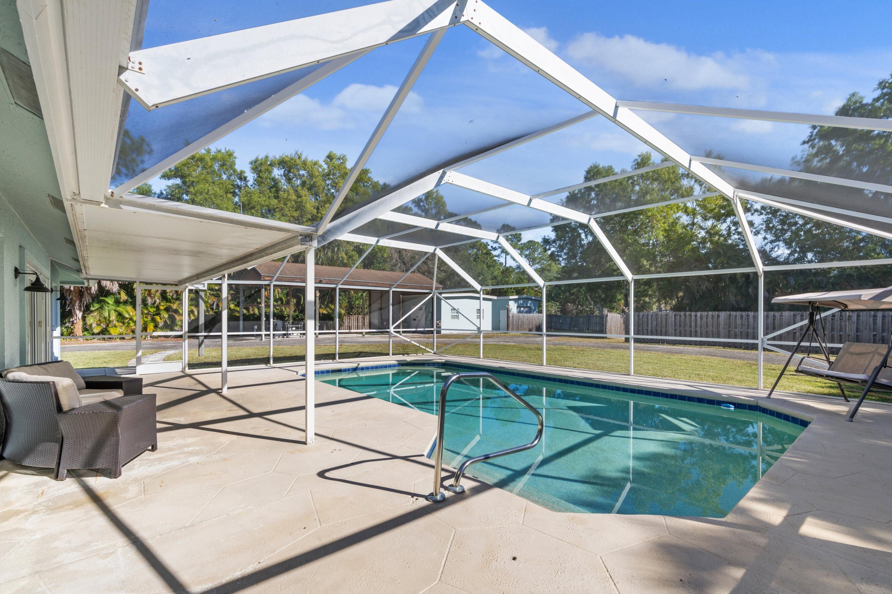 17392 Mellen Lane Jupiter, FL 33478 - Photo 19 of 38 a view of a swimming pool with a patio and a yard