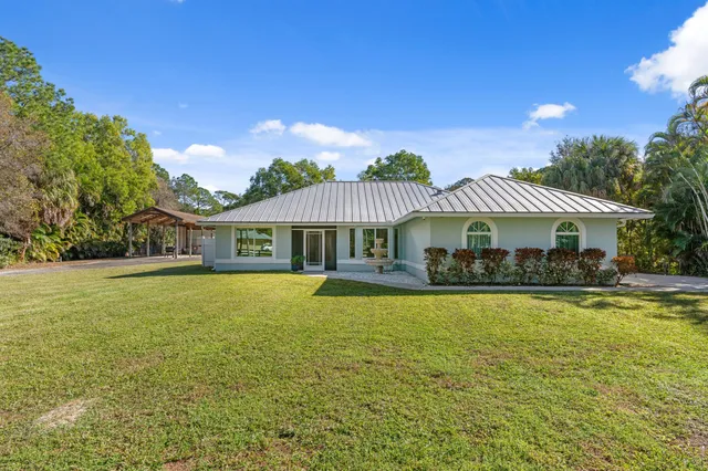a front view of a house with swimming pool having outdoor seating