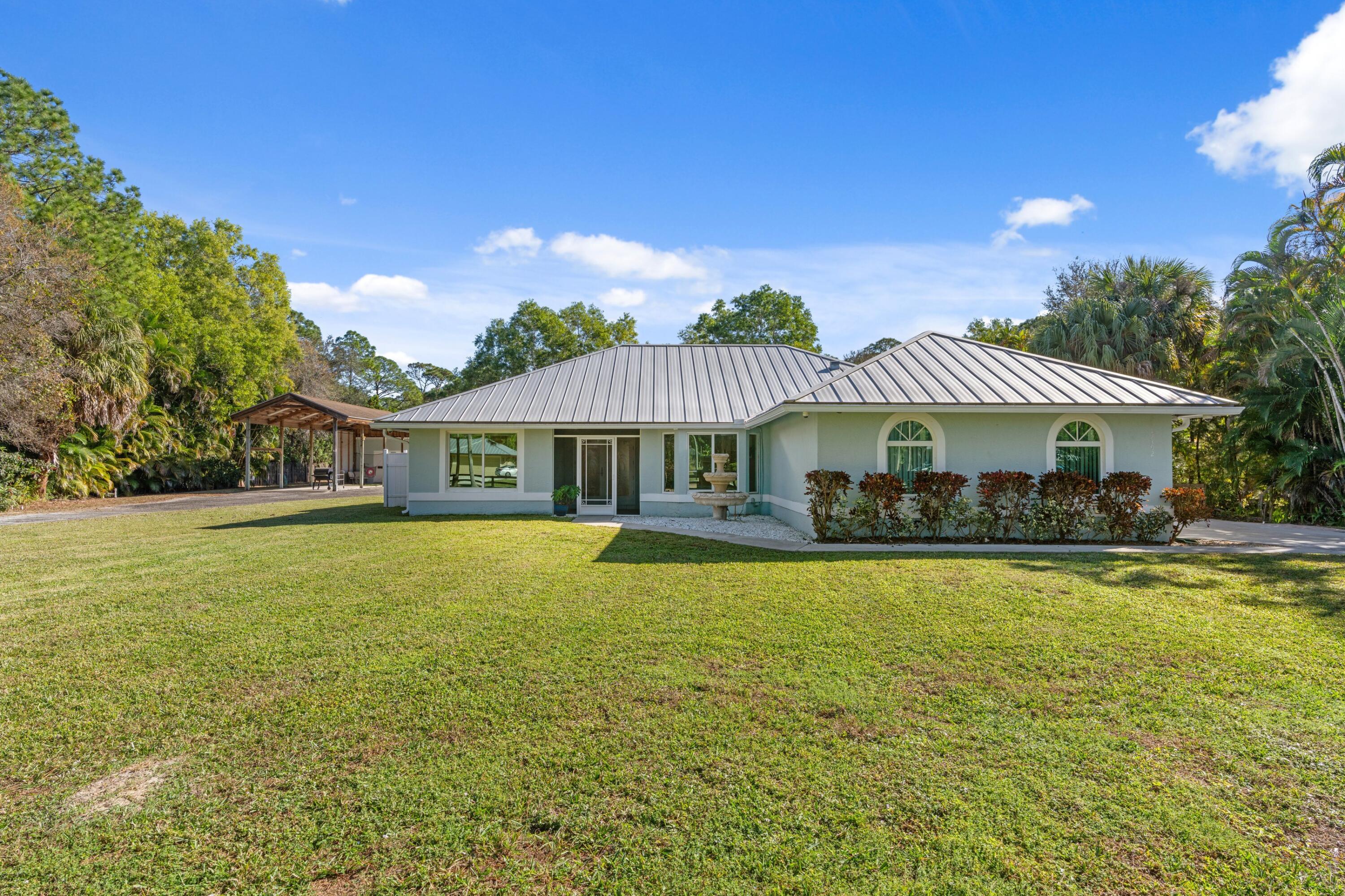 17392 Mellen Lane Jupiter, FL 33478 - Photo 29 of 38 a front view of a house with swimming pool having outdoor seating