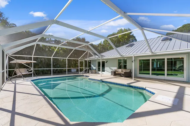 a view of a house with backyard and sitting area