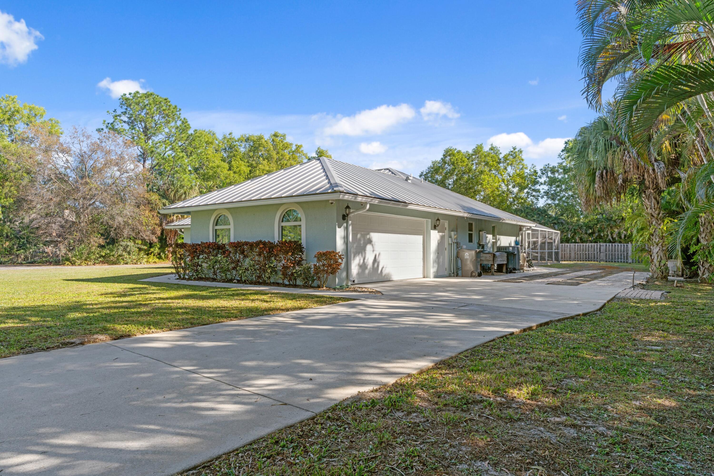 17392 Mellen Lane Jupiter, FL 33478 - Photo 31 of 38 a front view of house with yard and green space