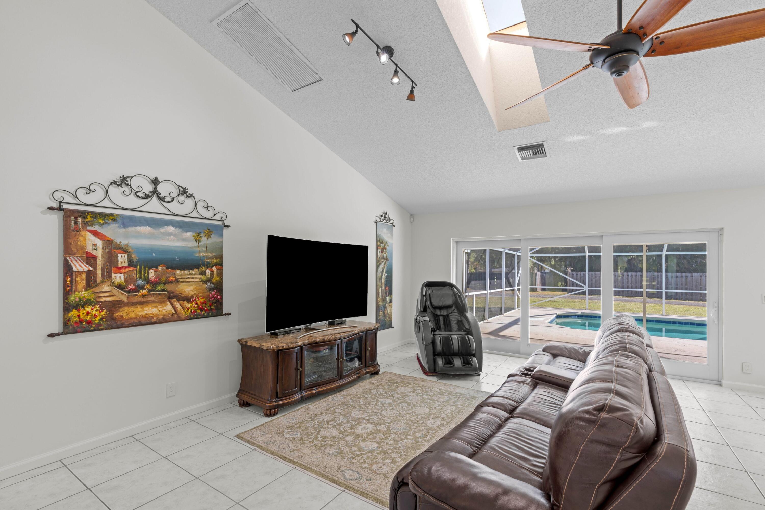 17392 Mellen Lane Jupiter, FL 33478 - Photo 5 of 38 a living room with furniture and a flat screen tv