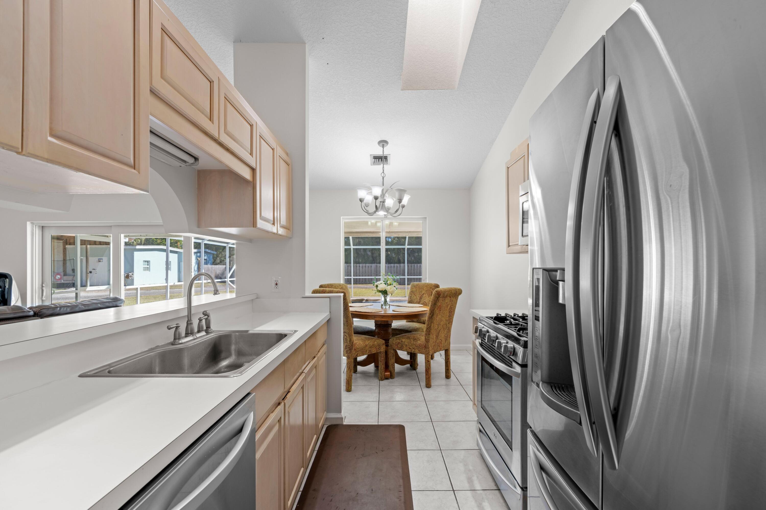 17392 Mellen Lane Jupiter, FL 33478 - Photo 6 of 38 a kitchen with stainless steel appliances granite countertop a refrigerator and a sink