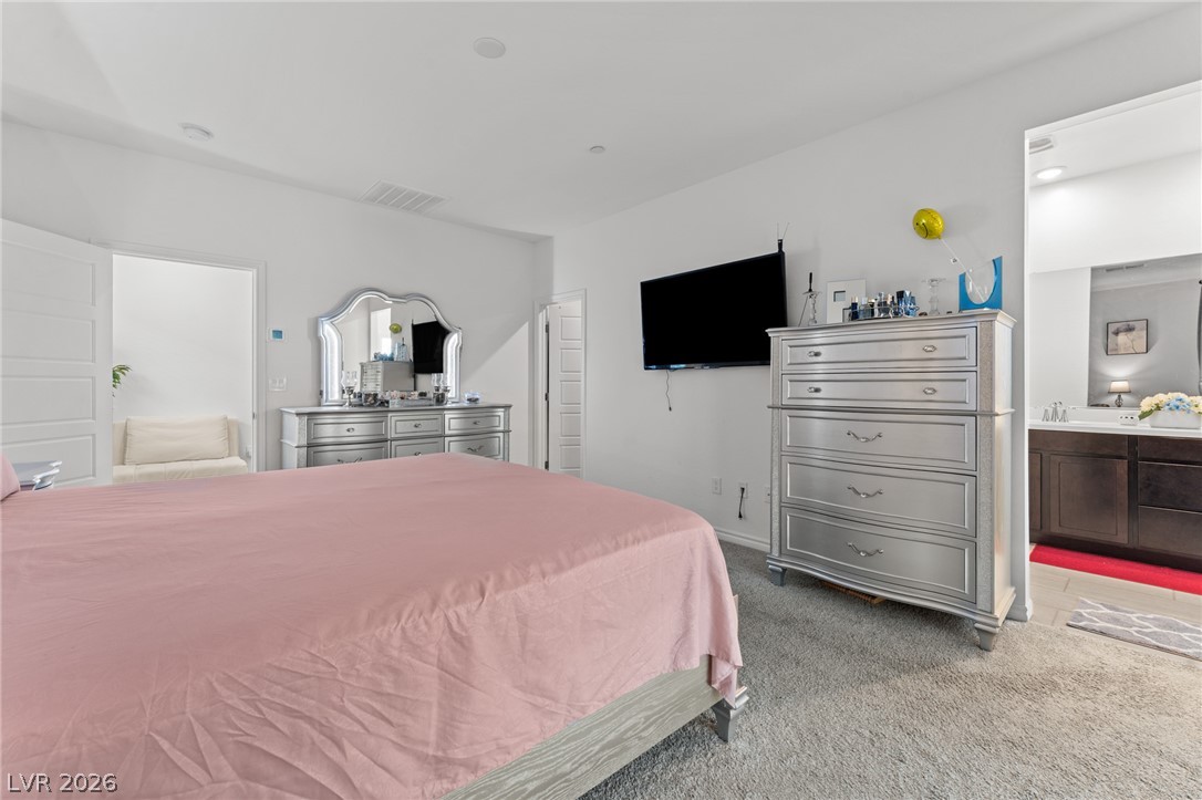 8879 Roadrunner Ravine Street Las Vegas, NV 89166 - Photo 21 of 39 Plush carpet underfoot welcomes you in this generously proportioned sleeping area, featuring an en suite bath.