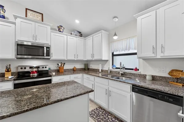 a kitchen with a sink dishwasher and stove