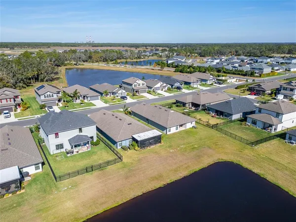an aerial view of a house with a garden and lake view