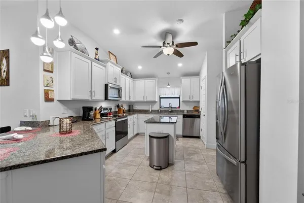 a kitchen with granite countertop a sink and a stove
