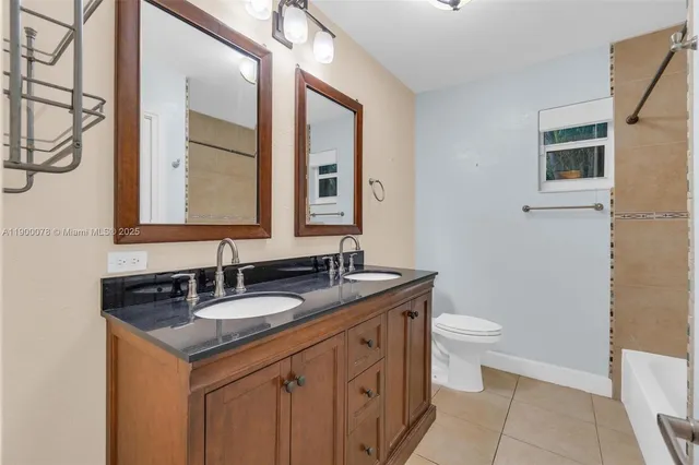 a bathroom with a granite countertop sink a toilet and a mirror