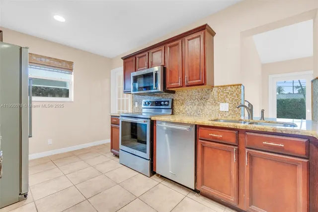 a kitchen with granite countertop a stove sink and cabinets
