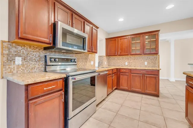 a kitchen with stainless steel appliances granite countertop a stove sink and cabinets