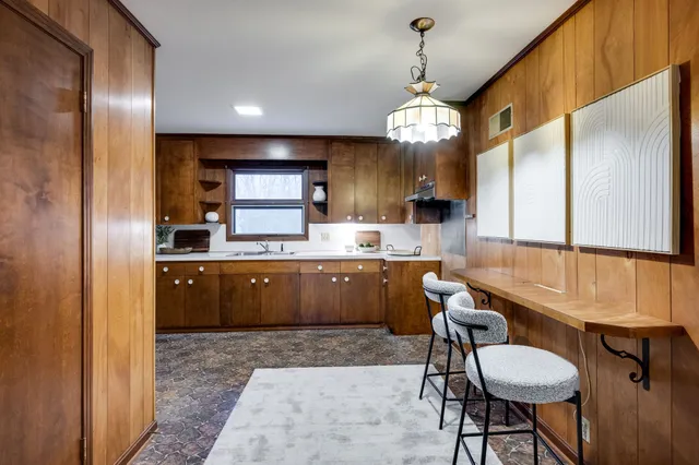 a kitchen with a dining table chairs cabinets and stainless steel appliances