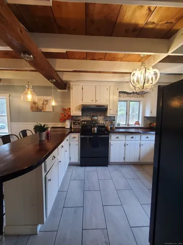 a large kitchen with a stove top oven a sink and cabinets