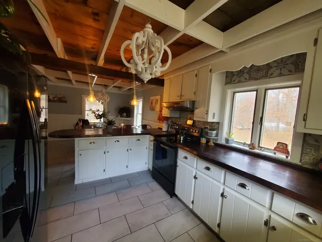 a kitchen with stainless steel appliances granite countertop a refrigerator a sink and white cabinets