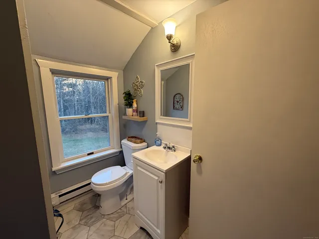 a bathroom with a toilet sink and mirror
