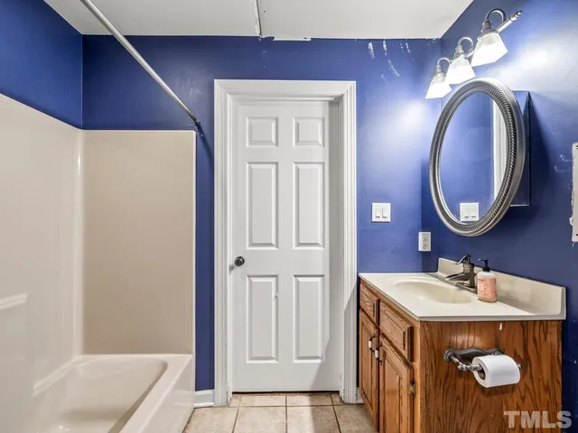a bathroom with a sink a mirror a vanity and a bathtub
