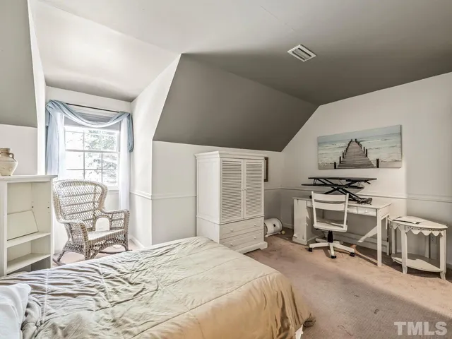 a bedroom with a bed and a chair with the wooden floor