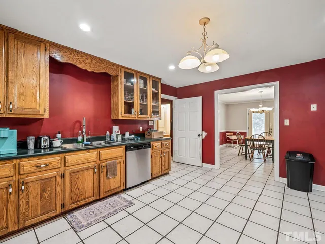 a kitchen with stainless steel appliances granite countertop a stove top oven a sink dishwasher and cabinets with wooden floor