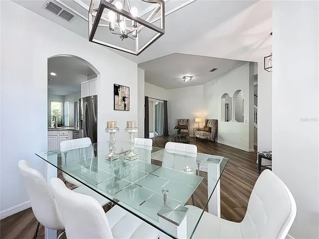 a dining room with wooden floor a chandelier