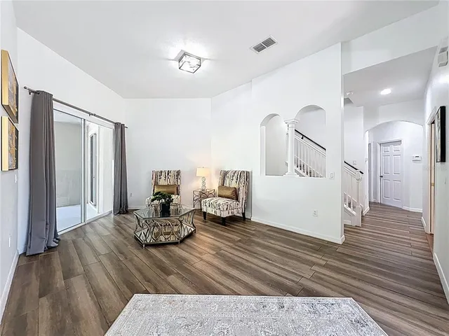 a living room with furniture and wooden floor
