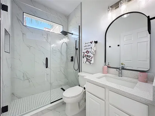 a bathroom with a sink toilet and shower