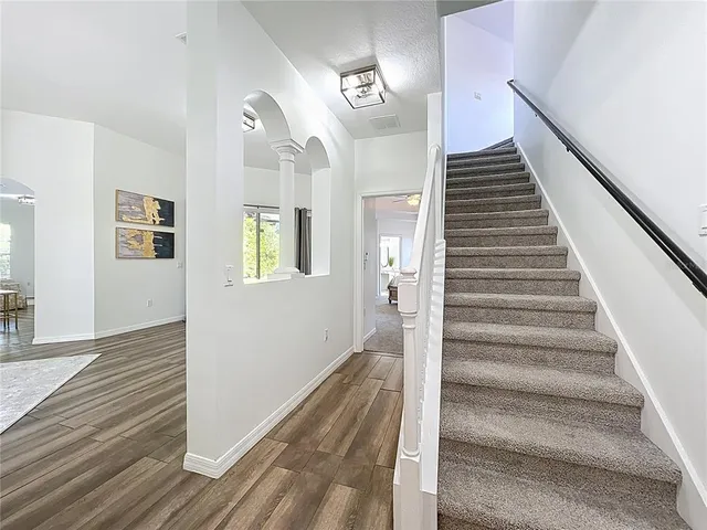 a view of a hallway with wooden floor and entryway