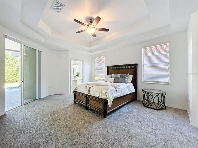 a bed sitting in a spacious bedroom next to a window