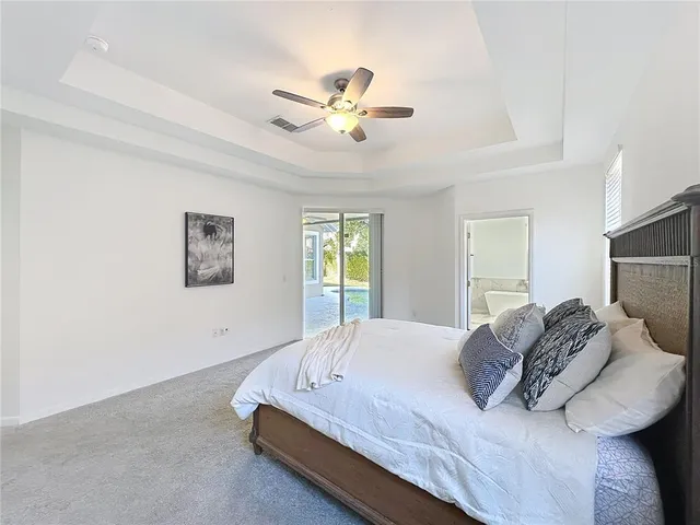 a spacious bedroom with a bed and a chandelier