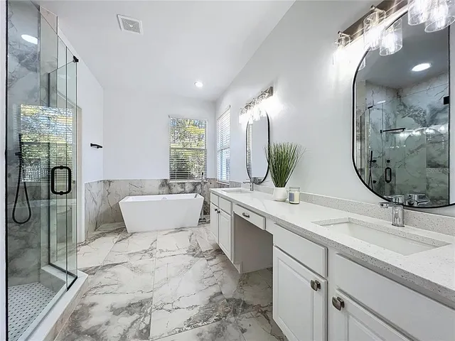 a bathroom with a double vanity sink mirror and bathtub