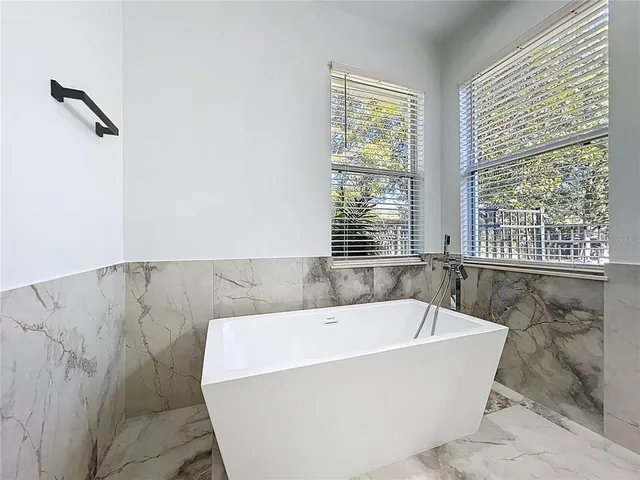 a bathroom with bathtub and window