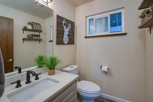a bathroom with a sink a toilet and a mirror