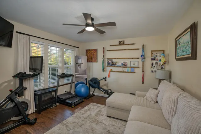 a living room with furniture a flat screen tv and a window