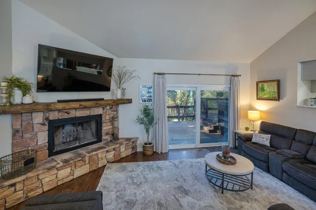 a living room with furniture a flat screen tv and a fireplace