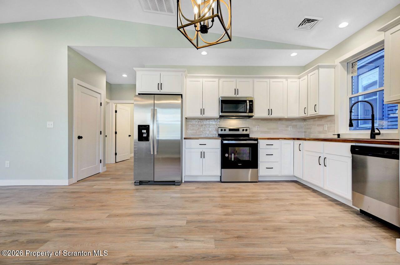 119 Prospect Avenue Scranton, PA 18505 - Photo 12 of 43 a kitchen with stainless steel appliances granite countertop a stove top oven a refrigerator a sink and dishwasher with wooden floor