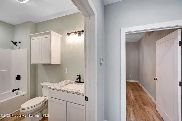 a bathroom with a granite countertop sink a toilet and shower