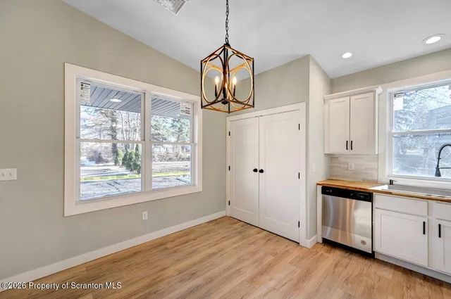 a view of a kitchen with wooden floor and windows