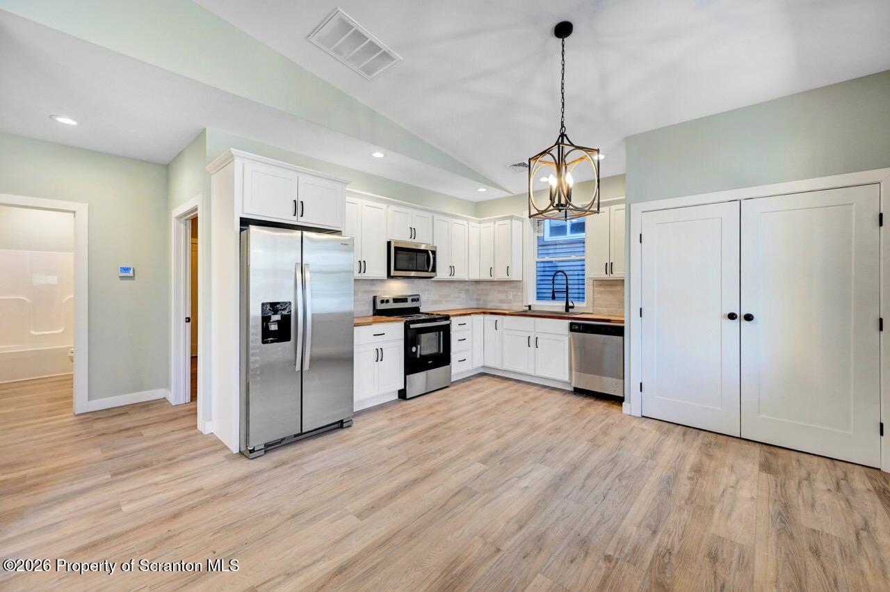 119 Prospect Avenue Scranton, PA 18505 - Photo 30 of 43 a kitchen with stainless steel appliances granite countertop a refrigerator a stove a sink and white cabinets with wooden floor