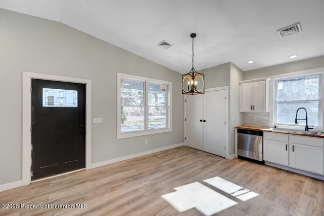 a view of a kitchen with a sink dishwasher and wooden floor