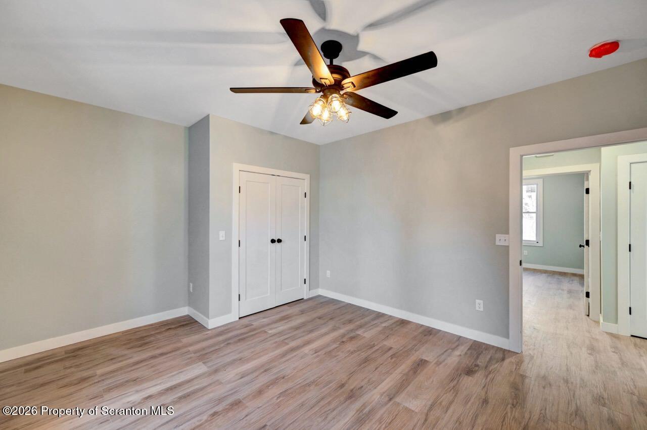 119 Prospect Avenue Scranton, PA 18505 - Photo 37 of 43 an empty room with wooden floor a ceiling fan and a window