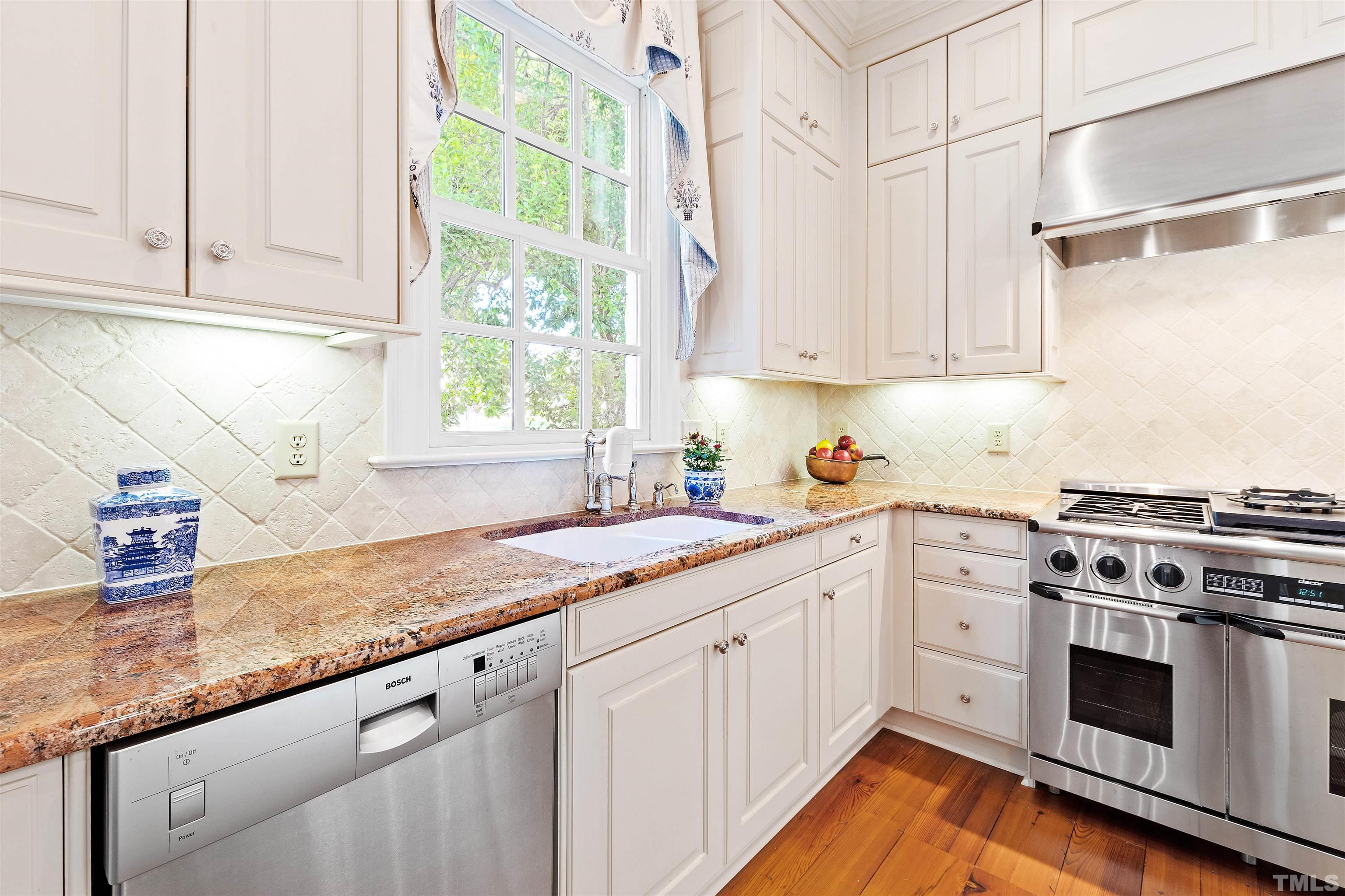 1029 Harvey Street Raleigh, NC 27608 - Photo 13 of 63 a kitchen with granite countertop white cabinets and white appliances