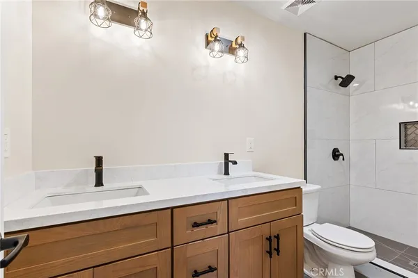 a bathroom with a sink a toilet and shower