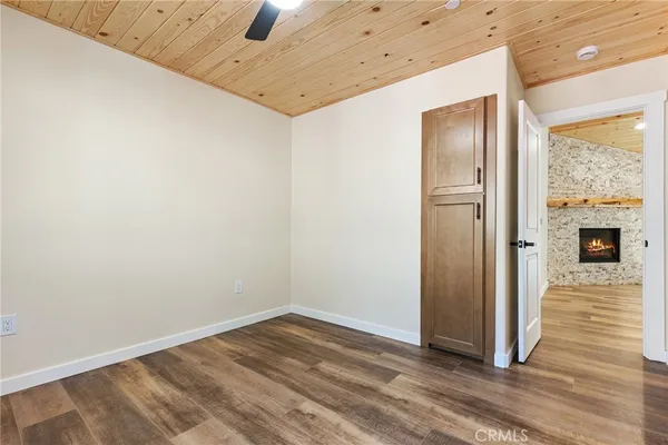 a view of a hallway with wooden floor and a bathroom