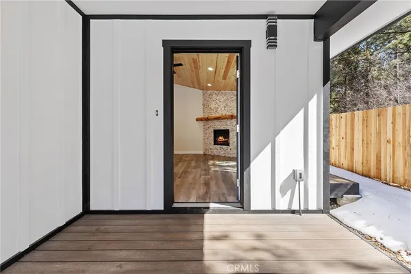 a view of a hallway with wooden floor and windows