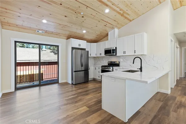 a kitchen with refrigerator cabinets and wooden floor