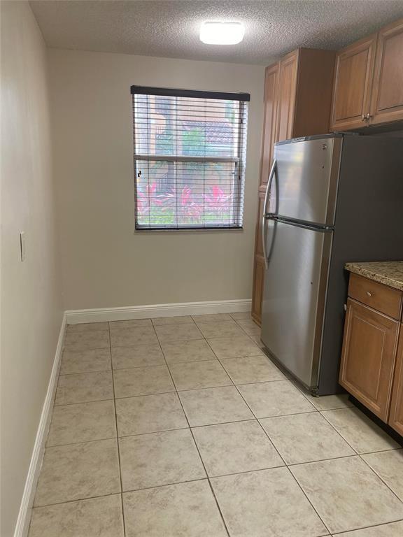 8701 Wiles Road, Unit 108 Coral Springs, FL 33067 - Photo 6 of 15 a kitchen with a refrigerator a washer and dryer