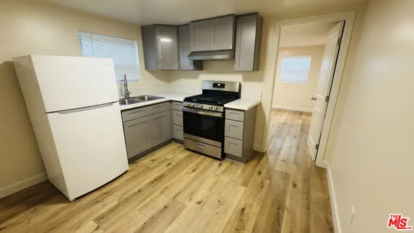 a kitchen with a refrigerator a stove top oven and a sink