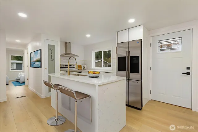 a kitchen with stainless steel appliances a stove refrigerator sink and microwave