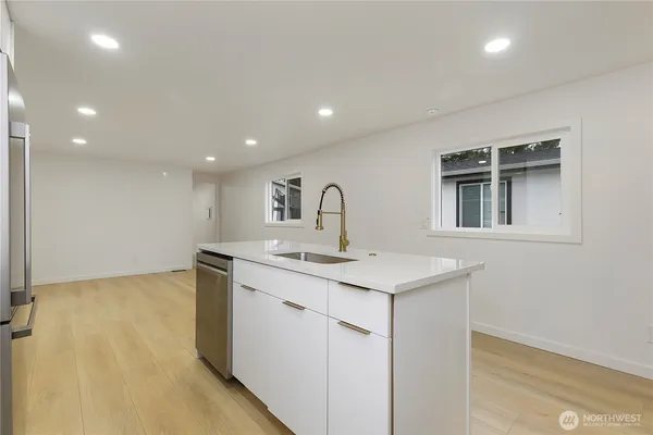 a kitchen with a sink a stove and cabinets