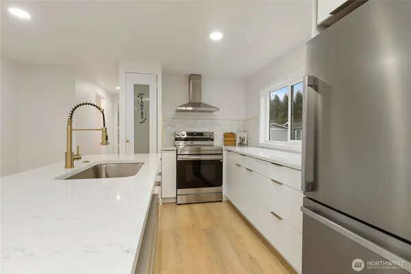 a kitchen with granite countertop a sink stainless steel appliances and cabinets